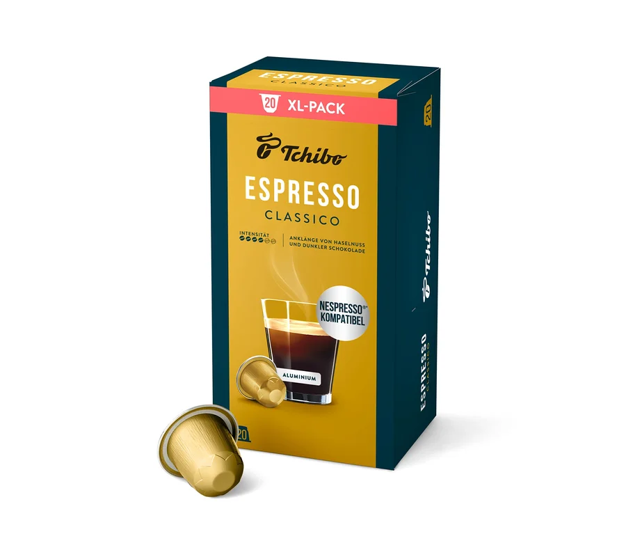 Boîte bleu foncé et jaune de capsules de café Tchibo Espresso Classico, avec les inscriptions "20 XL-PACK" et "NESPRESSO KOMPATIBEL". Deux capsules dorées sont posées devant.