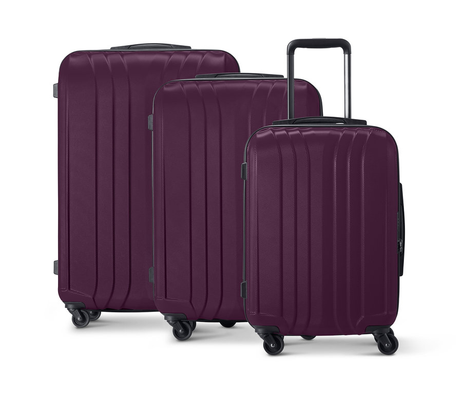 Trois valises rigides violettes de différentes tailles sont placées côte à côte.