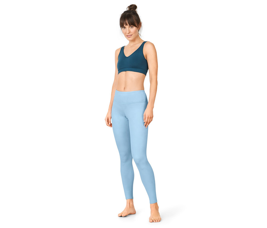 Femme portant un legging de sport réversible bleu.