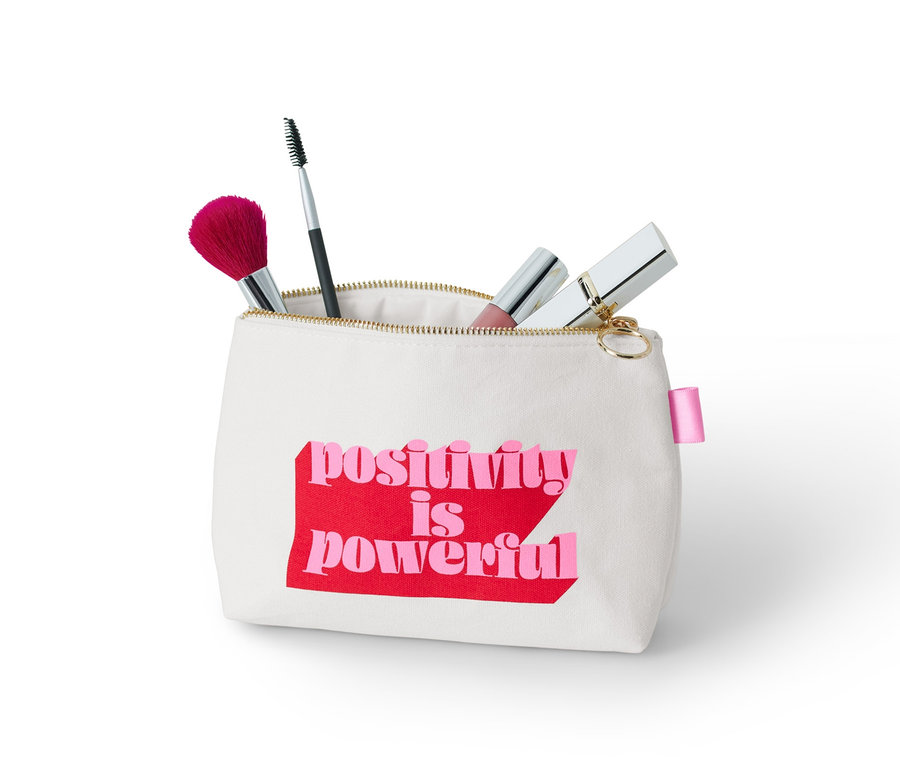 Une trousse à cosmétiques avec l'inscription "positivity is powerful" et des pinceaux de maquillage.