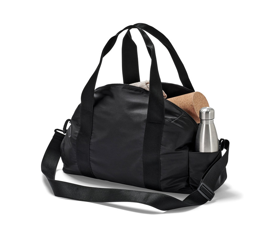 Un sac de sport noir avec une bouteille d'eau argentée et un bloc de liège.