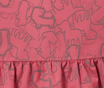 Détail d'une veste de pluie thermique pour enfant avec éléments réfléchissants et motif animalier.