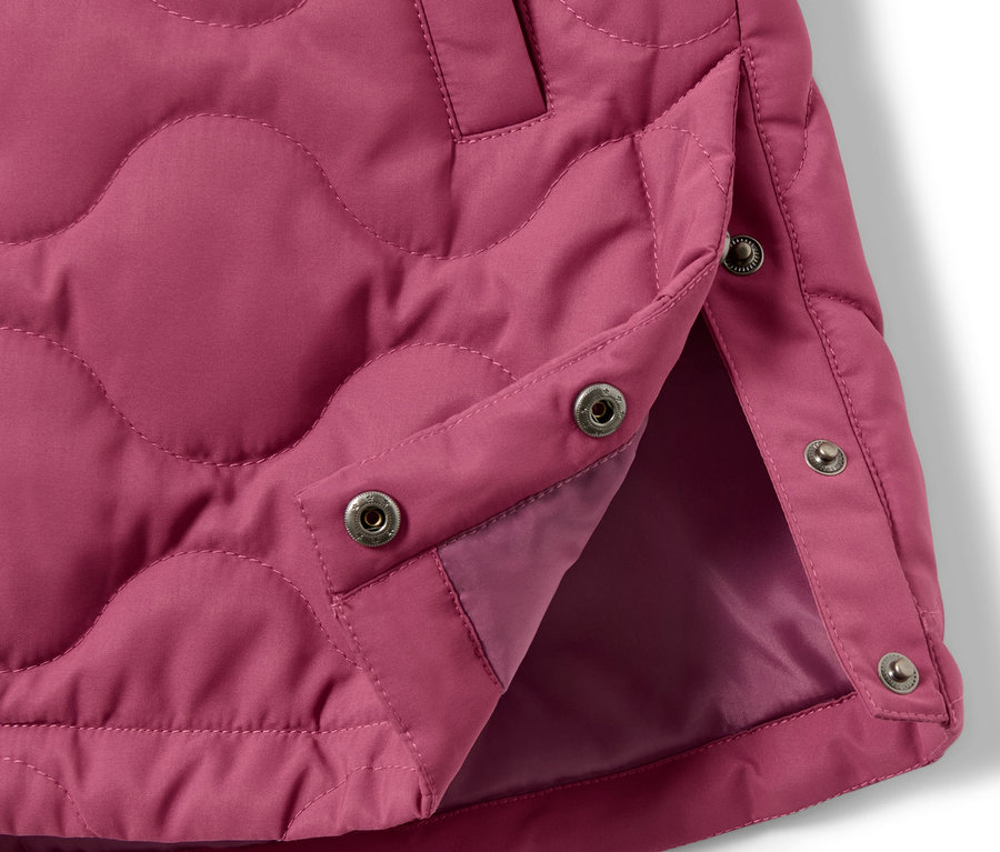 Détail d'un manteau matelassé pour enfant avec boutons-pression.