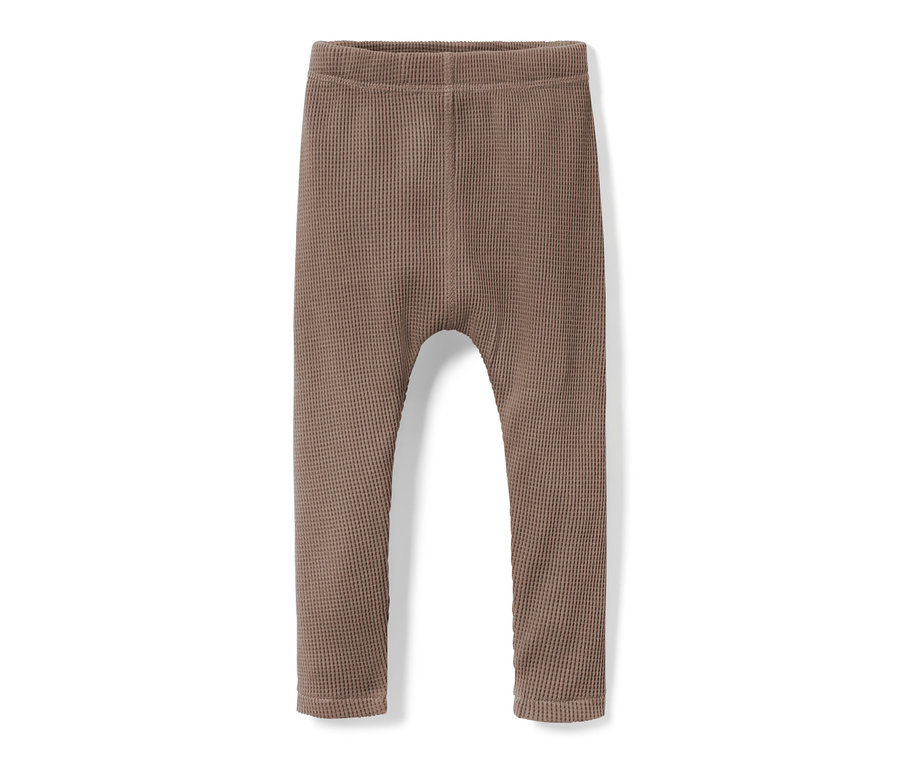 Un pantalon pour bébé marron texturé en gauffre sur fond blanc.
