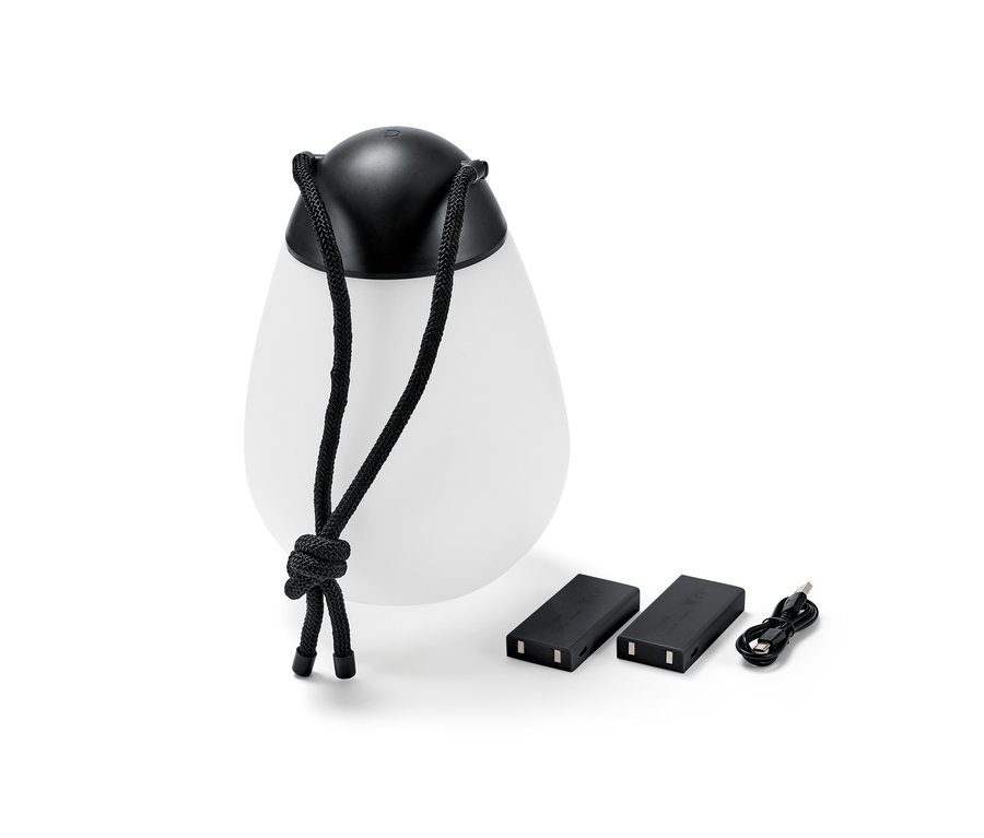 Une lampe à LED rechargeable avec batterie interchangeable supplémentaire, deux batteries et un câble USB sont posés à côté de la lampe.