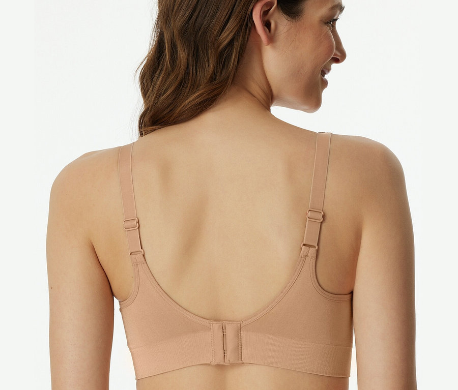 Vue arrière d'une femme aux cheveux bruns portant une brassière douce SCHIESSER avec coussinets, beige.