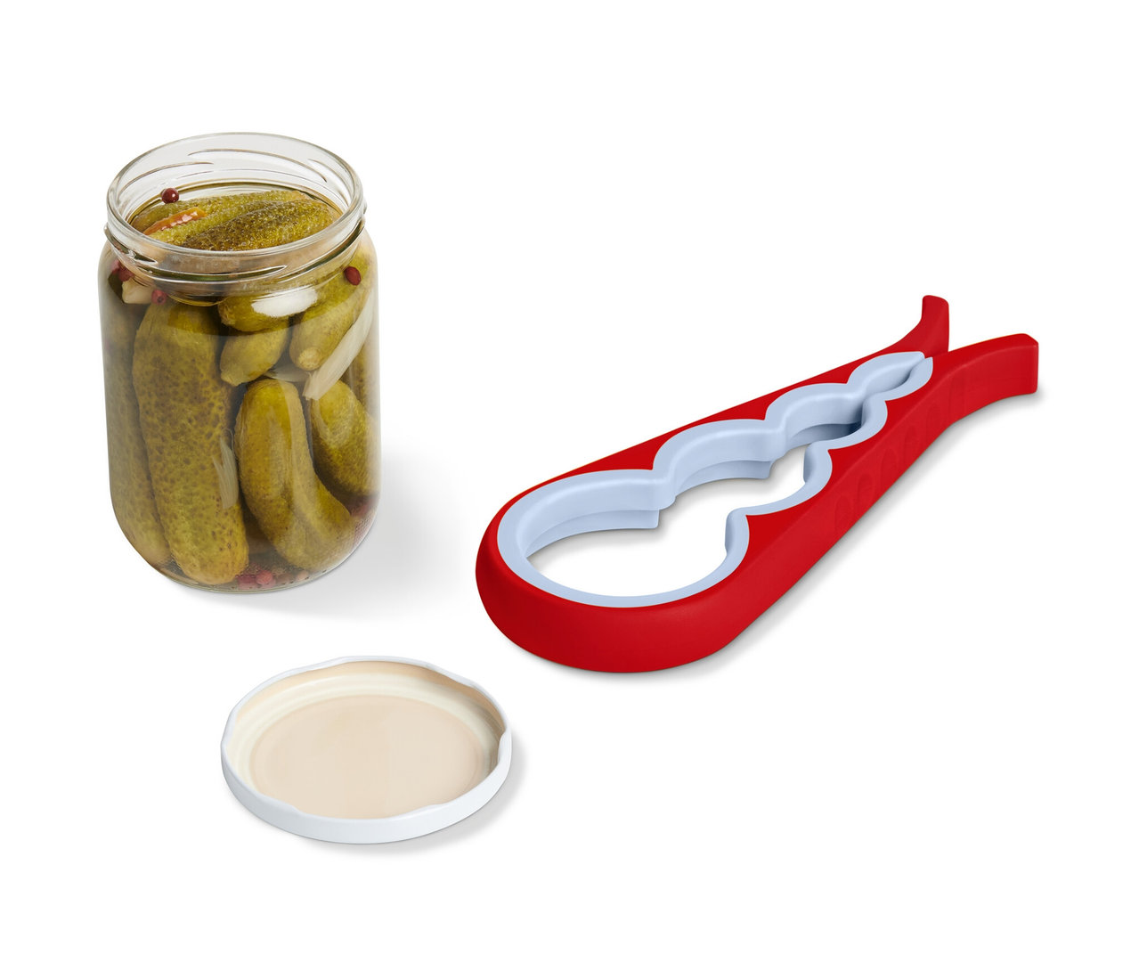Un bocal de cornichons, un couvercle et un ouvre-bocal et ouvre-bouteille sont placés l'un à côté de l'autre.