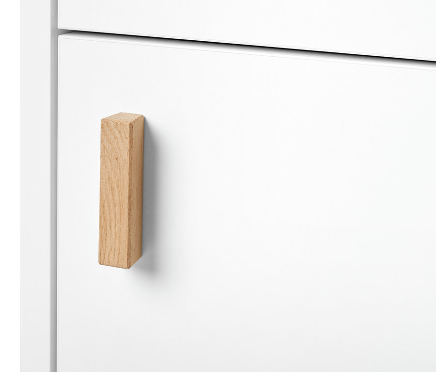 Détail d'une armoire haute de salle de bain étroite avec porte et poignée en bois.