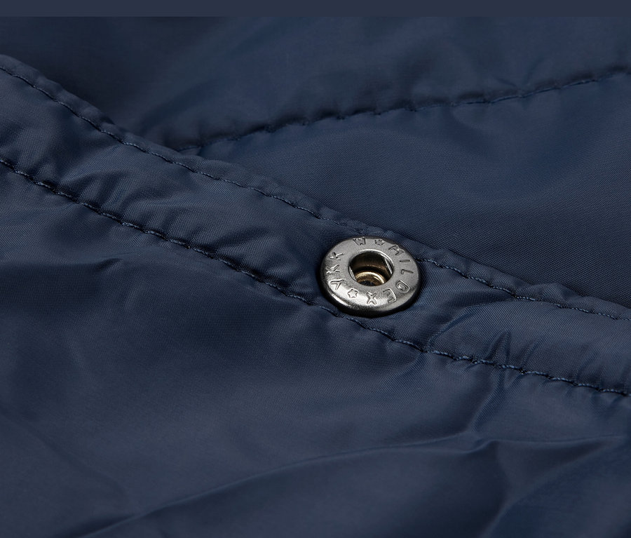 Gros plan d'une couverture de voyage ultralégère bleu foncé avec un bouton-pression.