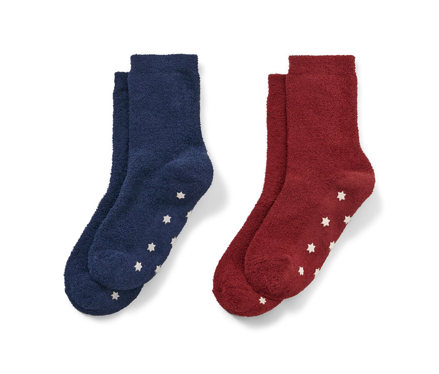 Deux paires de chaussettes moelleuses pour enfant : une paire bleu foncé et une paire rouge, toutes deux avec des étoiles blanches.