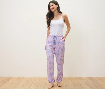 Femme debout, les mains dans les poches de son pantalon de pyjama