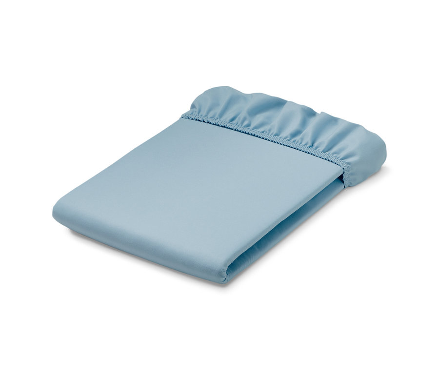 Un drap-housse en microfibre bleu clair plié sur un fond blanc.