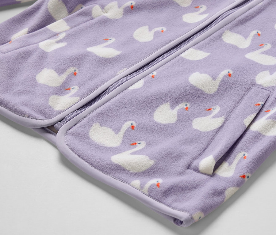 Gros plan sur une veste polaire pour enfant avec un motif de cygnes.