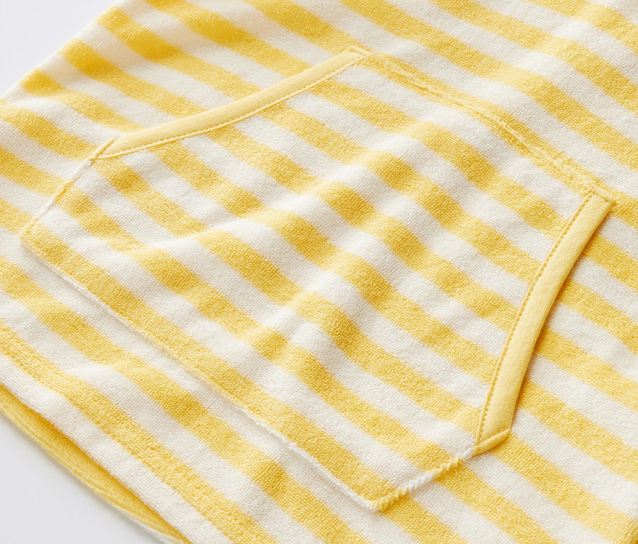 Gros plan sur un poncho en tissu éponge pour enfant, à rayures, avec poche.