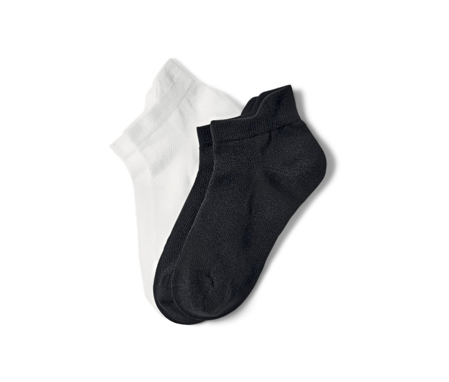 Deux paires de socquettes de sport, une paire blanche et une paire noire.