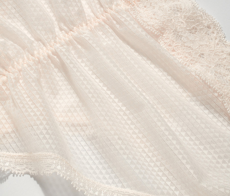 Gros plan sur une culotte rose clair avec de la dentelle.