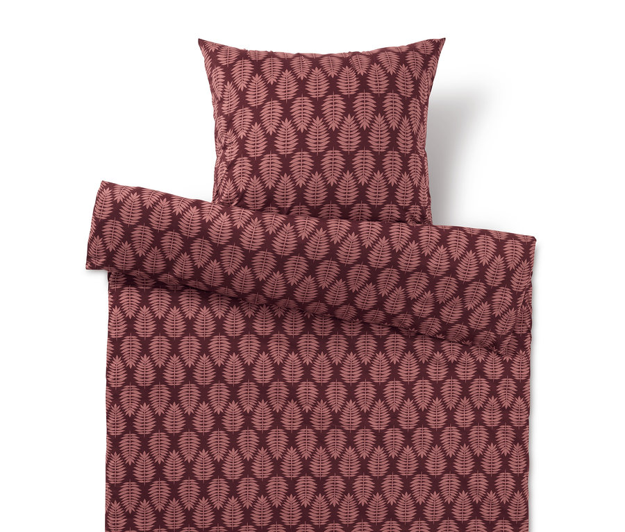 Housse de couette et oreiller avec motif de feuilles dans les tons rouges.