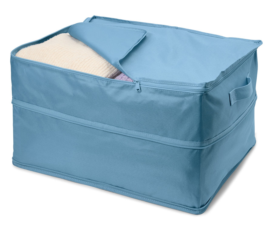 Boîte de rangement en tissu bleu avec un couvercle partiellement ouvert, révélant des vêtements blancs à l'intérieur.