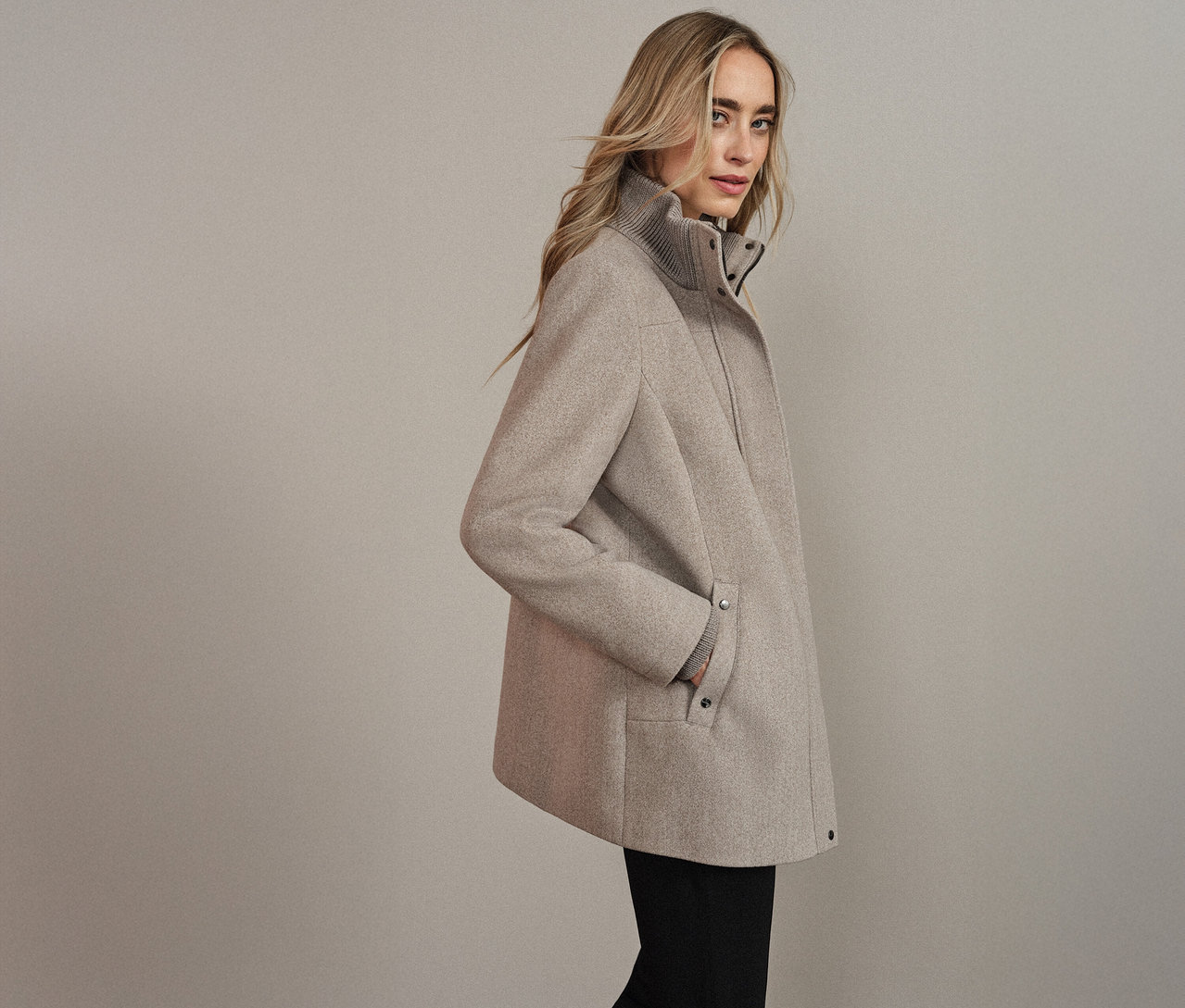 Femme portant un manteau court Street One beige, la main dans la poche.