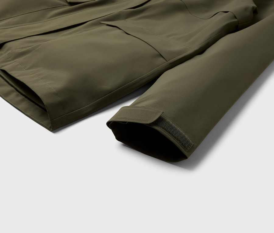 Gros plan sur une veste vert olive avec des poches et une manche.