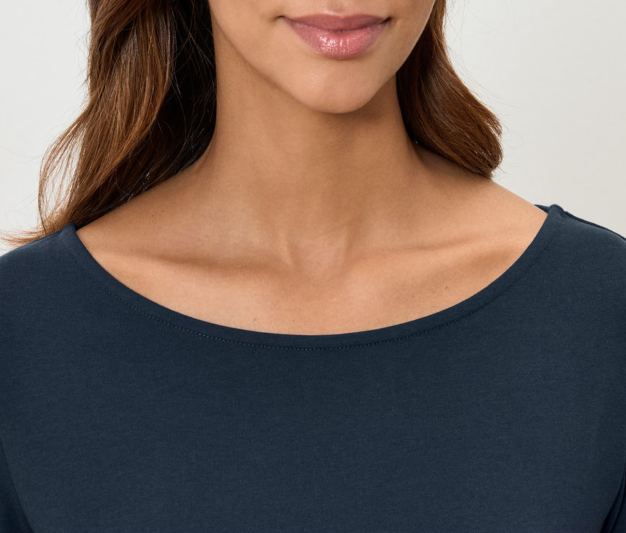 Gros plan d'un haut à manches longues bleu foncé pour femmes, montré des épaules à la lèvre supérieure.