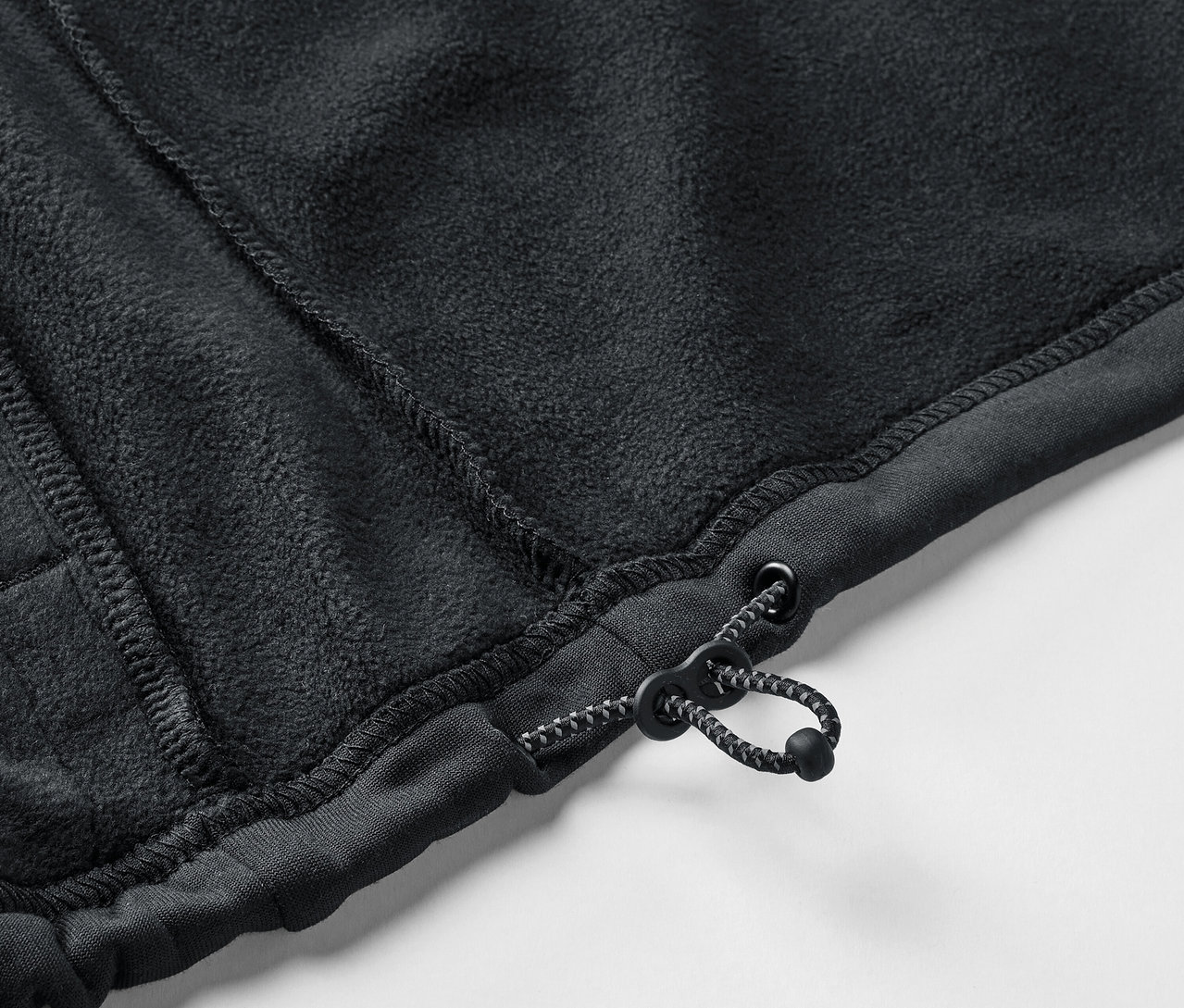 Gros plan sur un pull en polaire noir avec cordon de serrage.