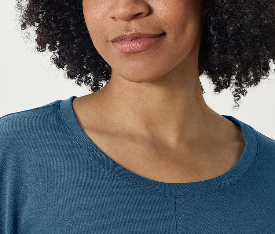 Gros plan sur le visage et le t-shirt bleu d'une femme.