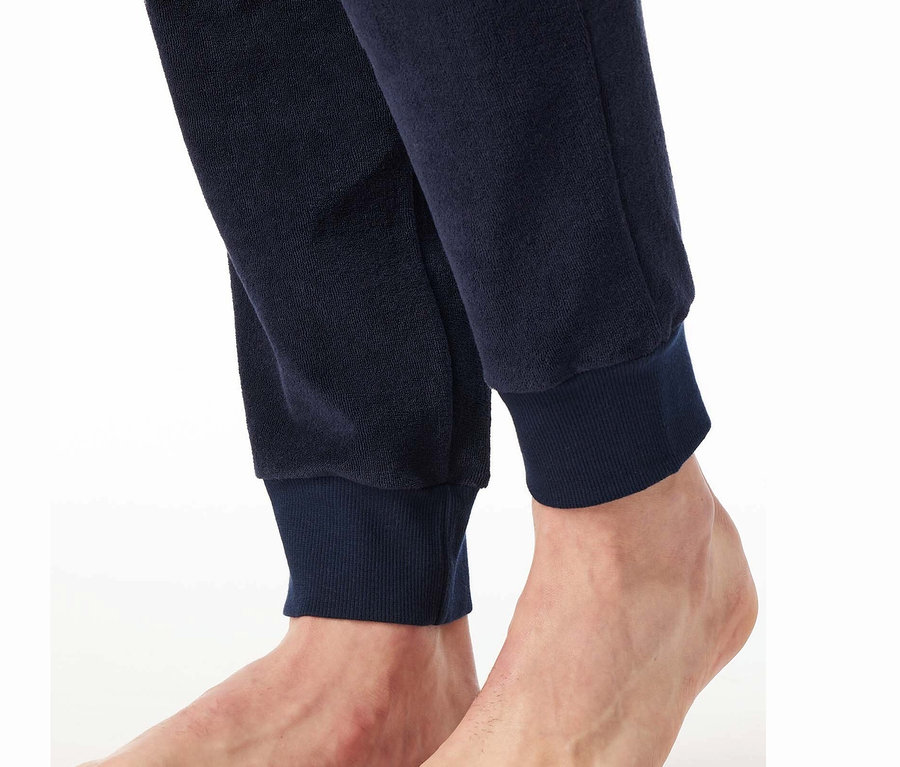 Gros plan des pieds et du bas d'un pantalon de survêtement bleu marine.