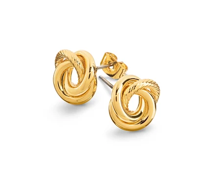Gros plan de deux boucles d'oreilles dorées en forme de nœud sur fond blanc.