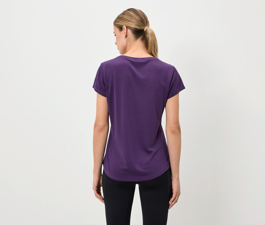 Vue de dos, une femme portant un t-shirt violet et un legging noir.