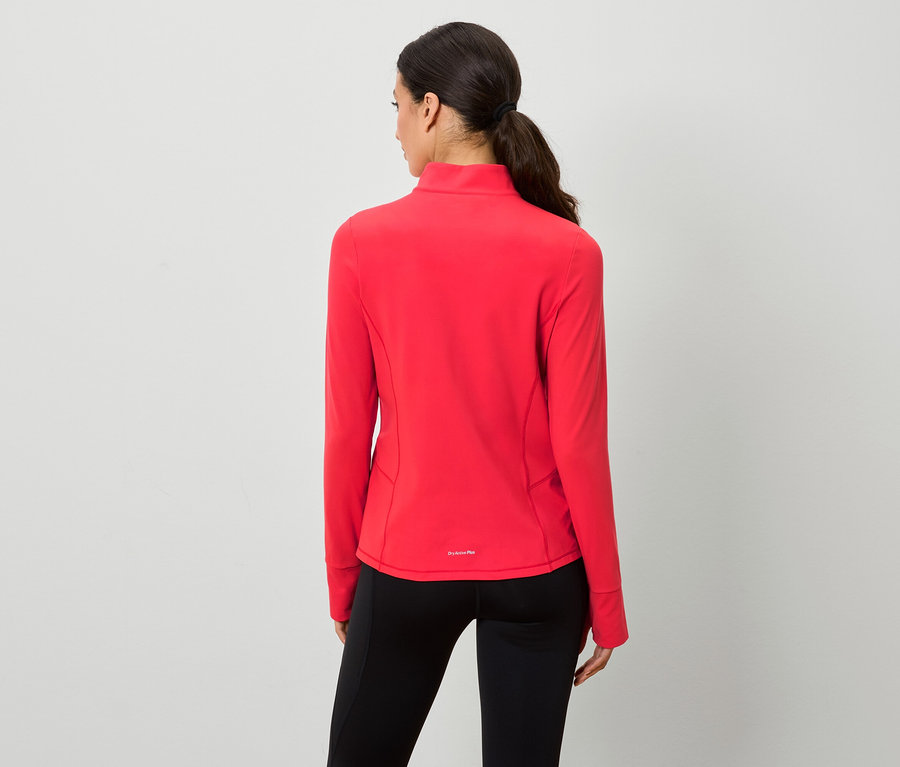 Une femme vue de dos porte un sweat-shirt rouge zippé et un legging noir.