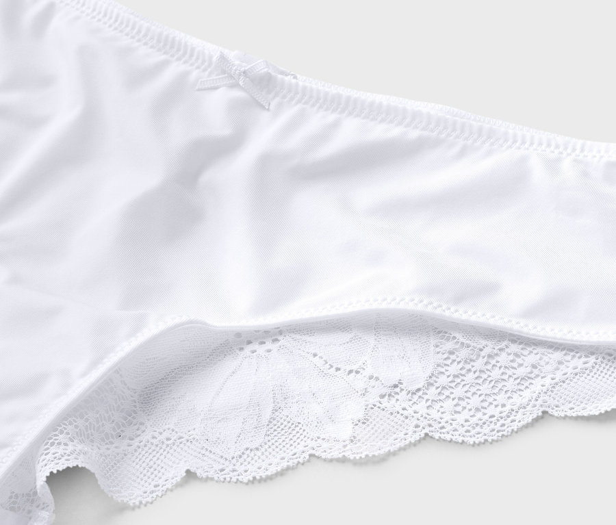 Gros plan sur des sous-vêtements blancs avec un nœud et des finitions en dentelle.