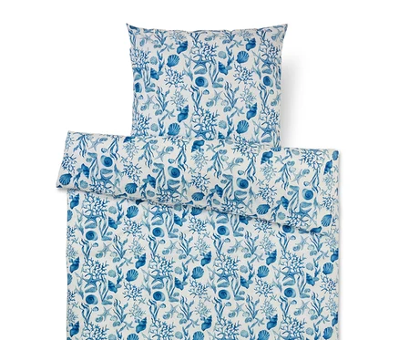 Ensemble de literie avec motif marin bleu de coraux, coquillages, étoiles de mer et algues sur fond blanc.