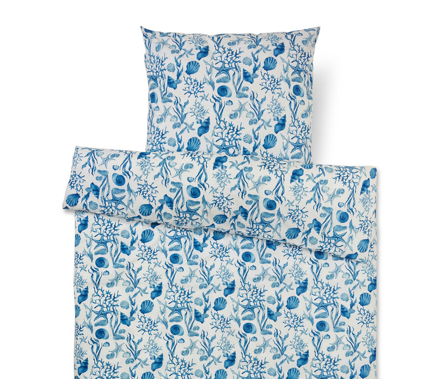 Ensemble de literie avec motif marin bleu de coraux, coquillages, étoiles de mer et algues sur fond blanc.