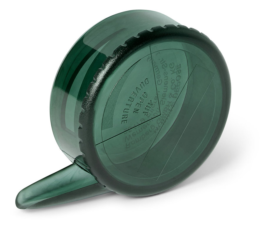 Gros plan d'une tasse à mesurer verte posée sur une surface blanche.