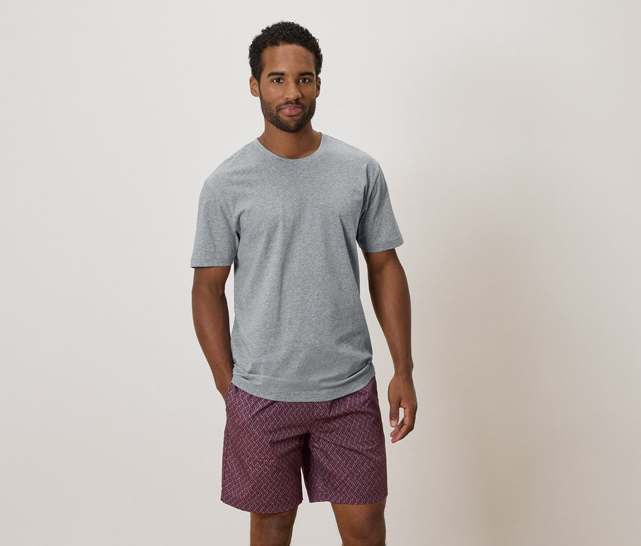 Homme portant un t-shirt gris et un short à motifs