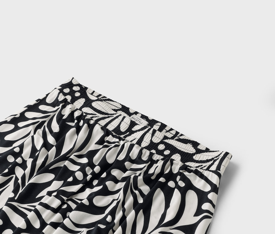 Gros plan de la taille d'un pantalon avec une ceinture élastique et un motif intégral noir et blanc.