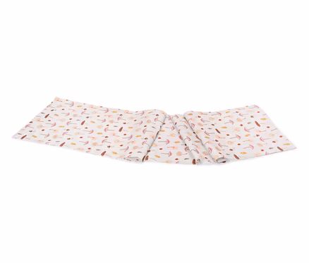 Chemin de table avec motif de champignons sur fond blanc, légèrement drapé.