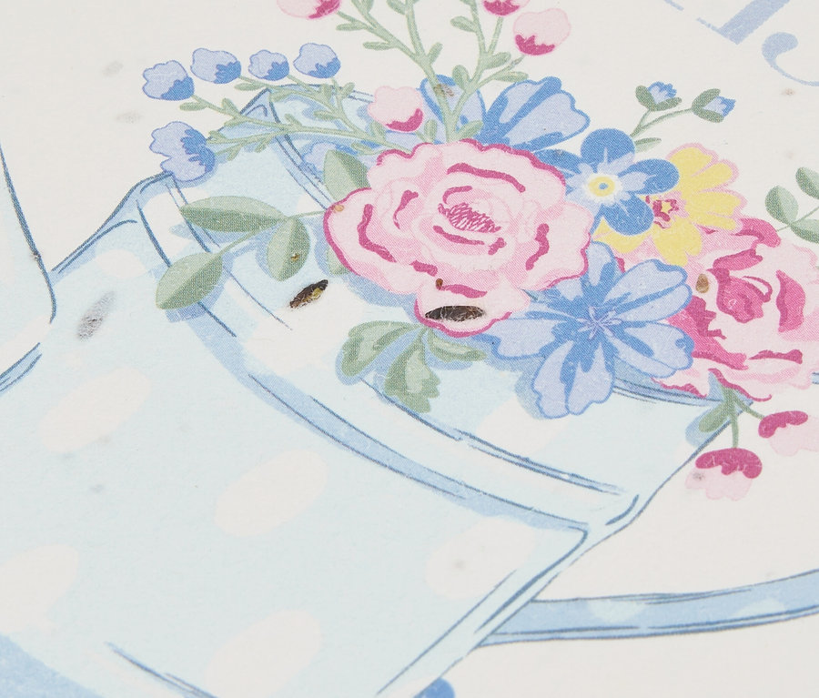 Gros plan d'une illustration d'un arrosoir bleu clair à pois rempli de fleurs.