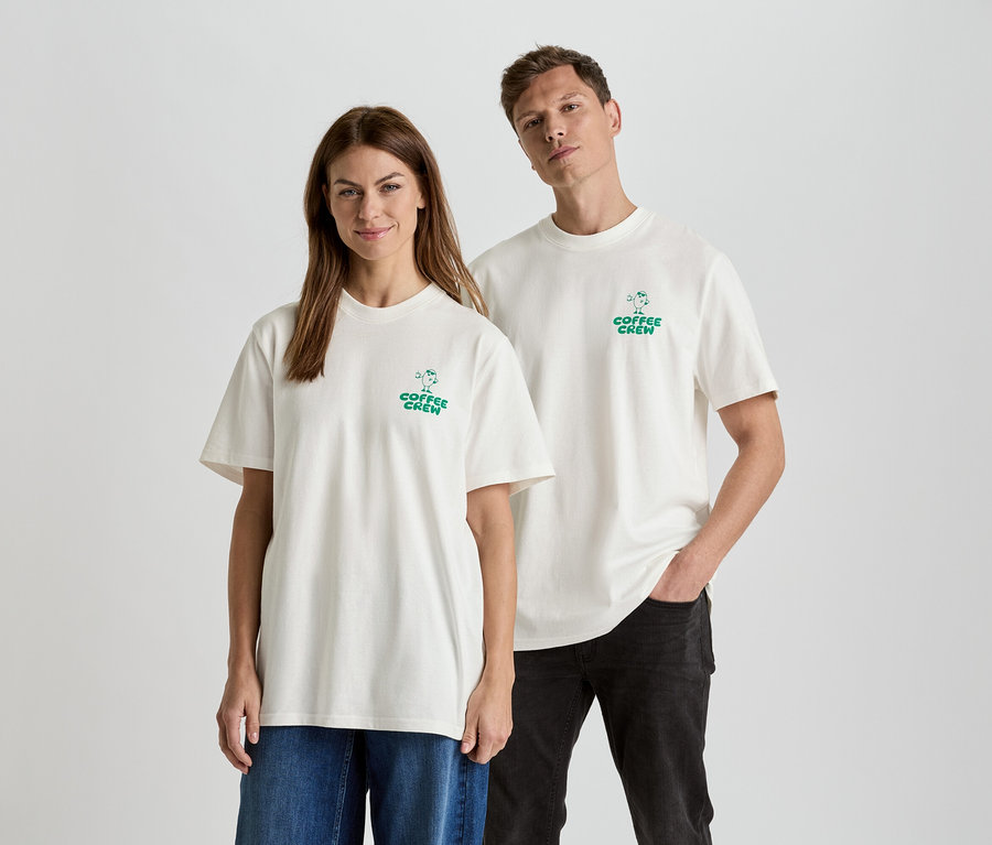 Une femme et un homme se tiennent côte à côte, portant des t-shirts assortis avec l'inscription "Coffee Crew".
