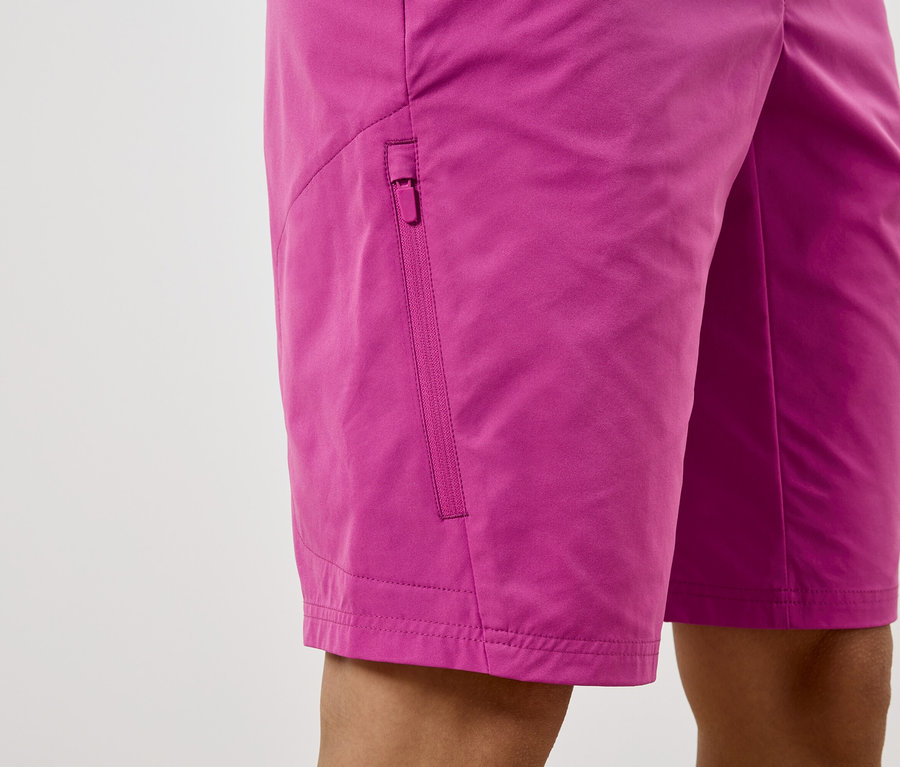 Gros plan sur un short rose avec une poche zippée.