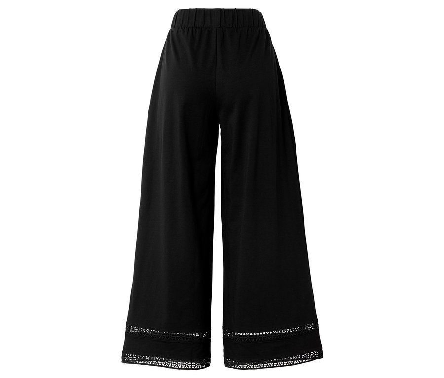 Pantalon noir à jambes larges avec taille élastique, fini avec de la dentelle en bas.