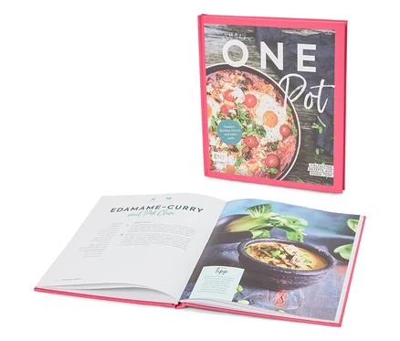 Un livre de cuisine intitulé « Simply One Pot » est ouvert sur une page contenant la recette du curry d'edamame au pak choi.