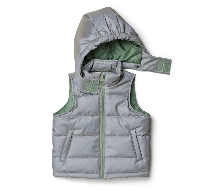 Veste matelassée réfléchissante pour enfants, argentée avec doublure verte et capuche amovible, posée à plat.