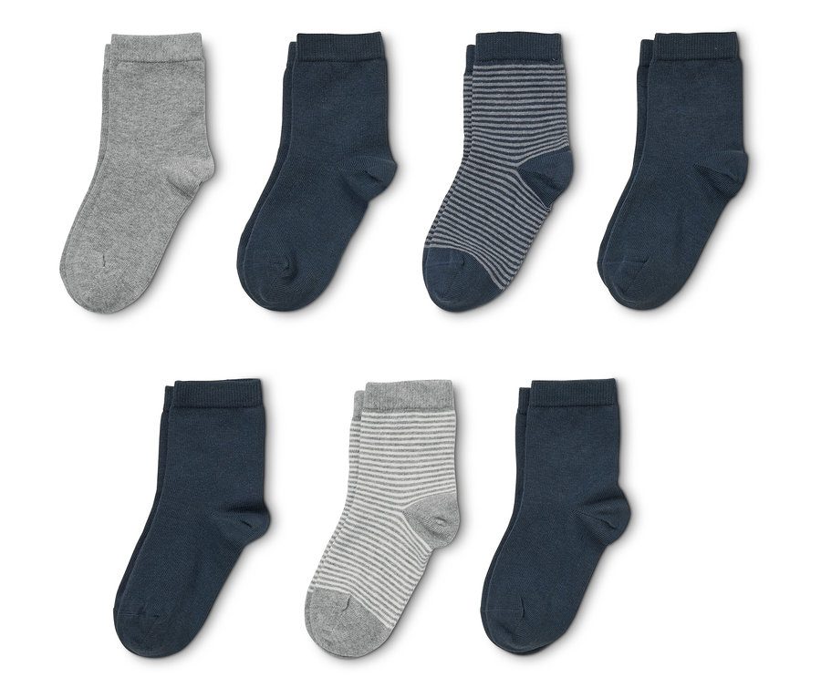 Sept chaussettes, dont des grises, bleu marine et rayées, posées sur un fond blanc.