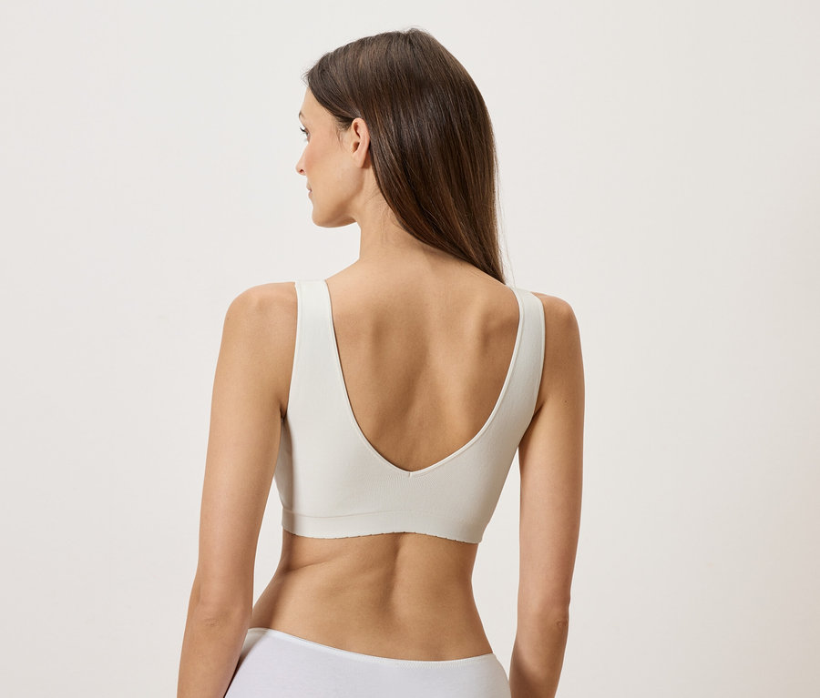 Femme vue de dos portant un soutien-gorge blanc.