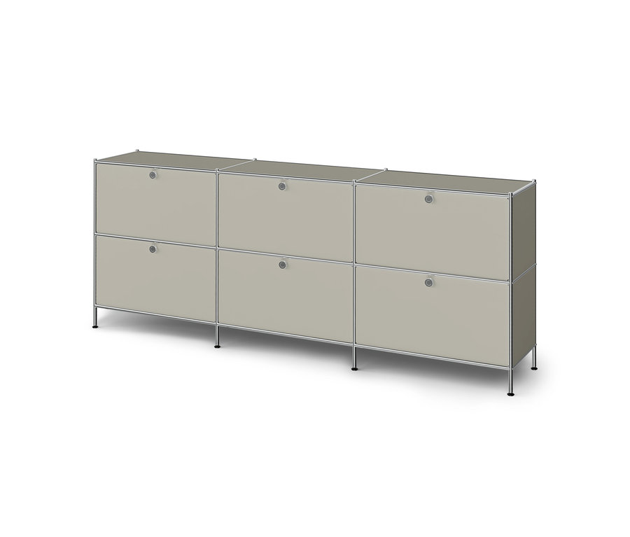 Long meuble bas modulaire gris clair avec cadre chromé, six portes à poignées rondes, reposant sur de courts pieds.