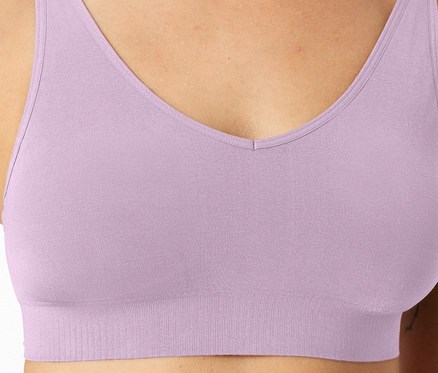 Gros plan d'une femme portant un soutien-gorge lilas clair avec un décolleté en V et une bande côtelée.