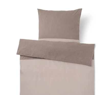 Parure de lit bicolore taupe et beige clair, comprenant un oreiller et une housse de couette repliée.