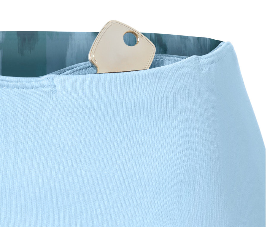 Détail d'un legging de sport réversible bleu avec une clé dans la poche.